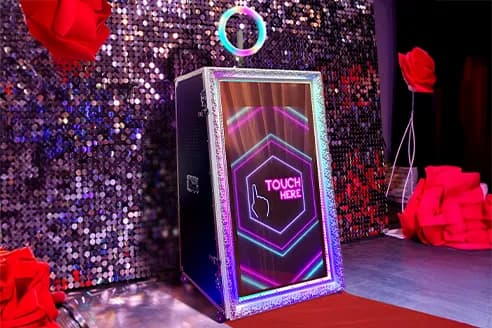Guests posing at a mirror photo booth